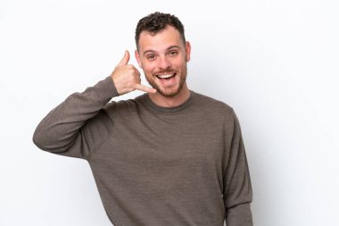 Beyaz arka planda izole edilmiş genç Brezilyalı bir adam telefon jesti yapıyor. Bana geri dönüş işareti ver.