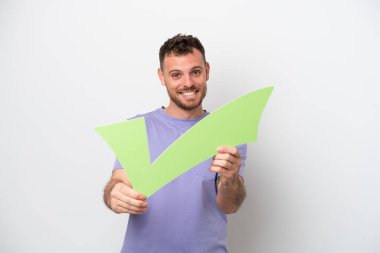 Beyaz arka planda izole edilmiş Brezilyalı genç bir adam elinde mutlu bir ifadeyle bir çek simgesi tutuyor.