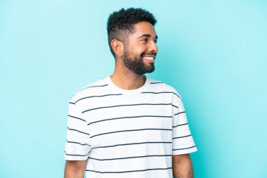 Mavi arka planda izole edilmiş genç Brezilyalı adam.