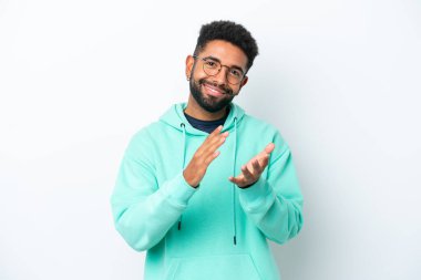 Beyaz arka planda izole edilmiş genç Brezilyalı bir adam bir konferanstan sonra alkışlıyor.