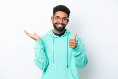 Beyaz arka planda izole edilmiş genç Brezilyalı bir adam. Kopyalama alanı hayali bir şey tutuyor. Bir ilan vermek için.