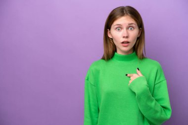 Mor arka planda izole edilmiş genç bir İngiliz kadın kendini işaret ediyor.