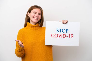 Beyaz arka planda izole edilmiş genç bir İngiliz kadın elinde yazılı bir pankartla Covid 19 ile anlaşma yapıyor.