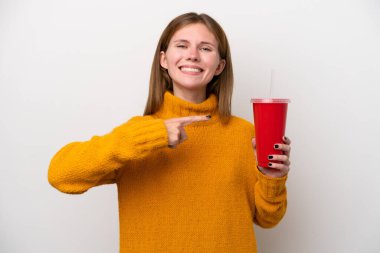 Soda tutan genç İngiliz kadın beyaz arka planda izole edilmiş ve onu işaret ediyor.