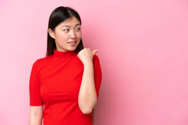 Joven Mujer China Aislada Sobre Fondo Rosa Apuntando Hacia Lado —  Fotos de Stock