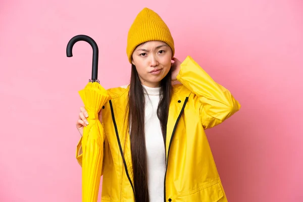 Young Chinese Woman Rainproof Coat Umbrella Isolated Pink Background Having — Stockfoto