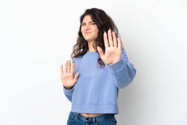 Beyaz arka planda izole edilmiş genç bir Rus kızı gergin bir şekilde ellerini öne uzatıyor.