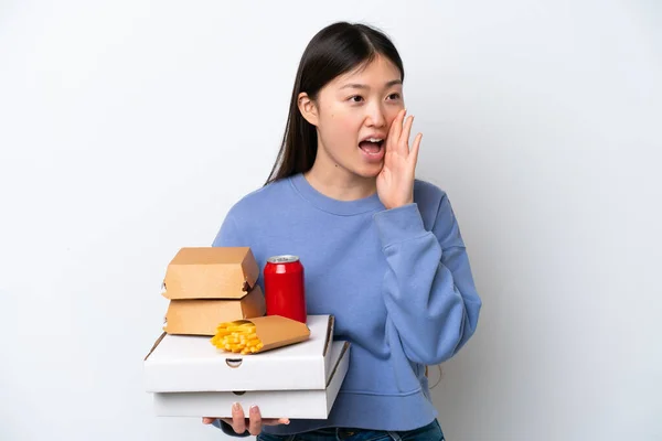 Młoda Chińska Kobieta Trzyma Fast Food Izolowane Białym Tle Krzycząc — Zdjęcie stockowe