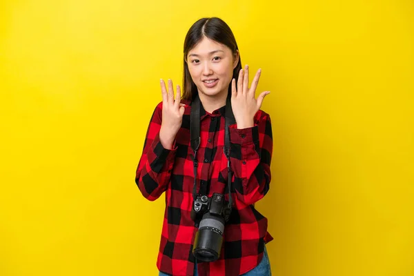 Joven Fotógrafa China Aislada Sobre Fondo Amarillo Contando Ocho Con —  Fotos de Stock