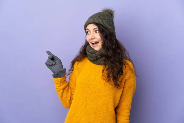 俄罗斯少女 头戴紫色背景的冬帽 想在举手表决时实现这个解决方案 — 图库照片