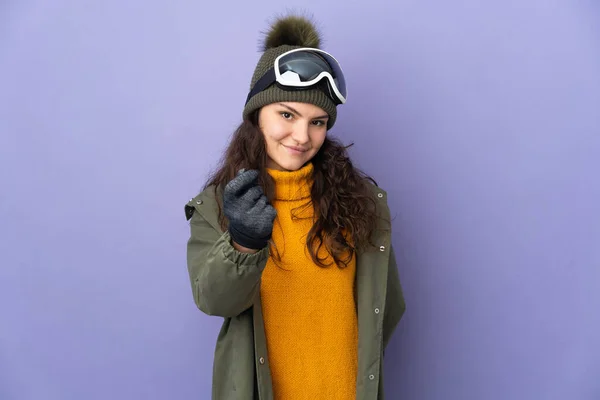 年轻的俄罗斯女孩 戴着雪板眼镜 背景紫色 做着赚钱的姿势 — 图库照片