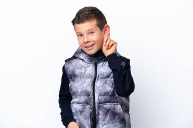 Küçük çocuk beyaz arka planda yalnız gülüyor.