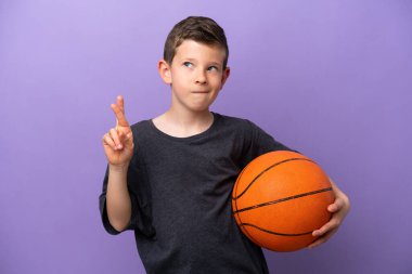 Mor arka planda basketbol oynayan küçük çocuk şans diliyor ve en iyisini diliyor.