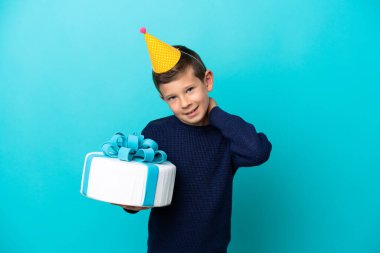 Küçük çocuk mavi arka planda izole edilmiş doğum günü pastası tutuyor.