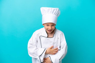 Küçük aşçı çocuk mavi arka planda izole edilmiş, gülümsüyor.