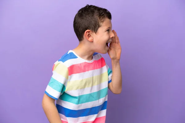 紫の背景に孤立した小さな男の子が叫びながら横に口を開けて — ストック写真