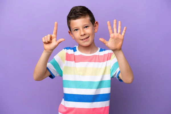 被紫色背景隔离的小男孩用手指数到七 — 图库照片