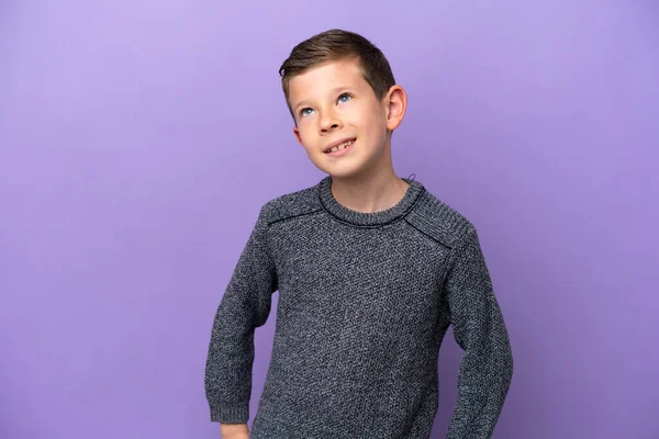 腰と笑顔で腕をポーズ紫色の背景に隔離された小さな男の子 — ストック写真