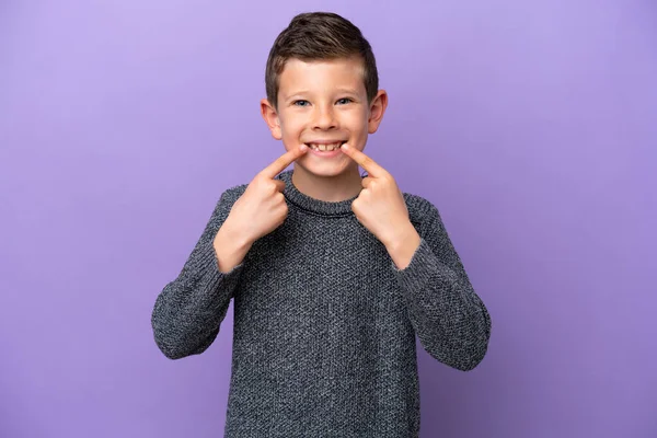 一个被紫色背景隔离的小男孩举起了一个大拇指 — 图库照片