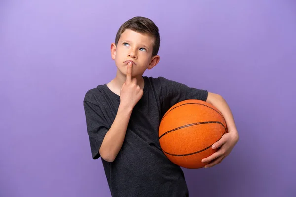 Niño Jugando Baloncesto Aislado Sobre Fondo Púrpura Teniendo Dudas Mientras — Foto de Stock