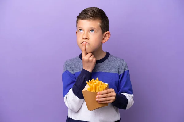 Kleine Jongen Met Gebakken Chips Geïsoleerd Paarse Achtergrond Met Twijfels — Stockfoto