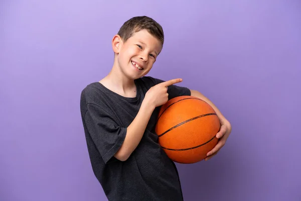 Niño Jugando Baloncesto Aislado Sobre Fondo Púrpura Apuntando Con Dedo — Foto de Stock