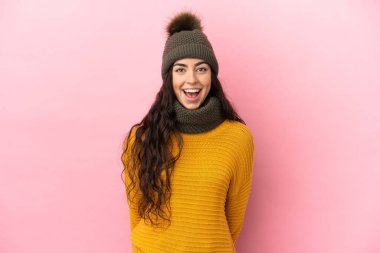 Kışlık şapkalı beyaz bir kız. Mor arka planda, şaşırmış bir yüz ifadesi var.