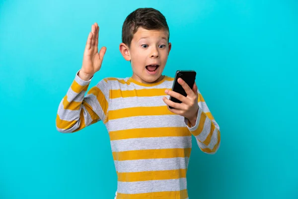 Little Boy Isolated Blue Background Looking Camera While Using Mobile — Stock Photo, Image