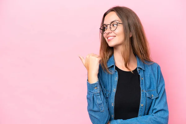 Mujer Joven Caucásica Aislada Sobre Fondo Rosa Apuntando Hacia Lado —  Fotos de Stock