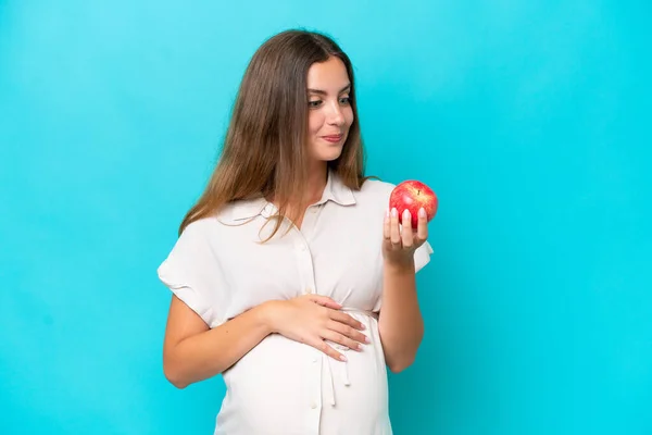 Young Caucasian Woman Isolated Blue Background Pregnant Holding Apple — Foto de Stock