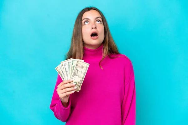 Young Caucasian Woman Taking Lot Money Isolated Blue Background Looking — Foto de Stock