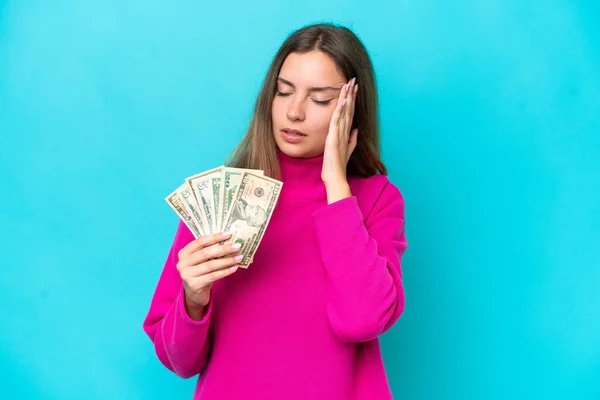 Young Caucasian Woman Taking Lot Money Isolated Blue Background Headache — Foto de Stock