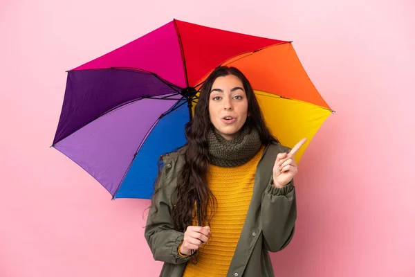 Pembe Arka Planda Izole Edilmiş Şemsiyeyi Tutan Genç Bir Kadın — Stok fotoğraf