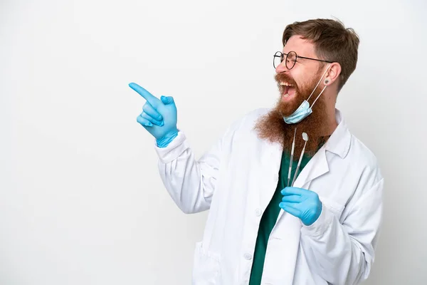 Стоматолог Рыжеволосый Человек Держащий Инструменты Изолированными Белом Фоне Указывая Пальцем — стоковое фото