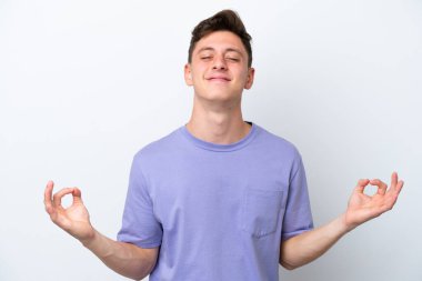 Genç ve yakışıklı Brezilyalı bir adam Zen pozunda beyaz arka planda izole edilmiş.