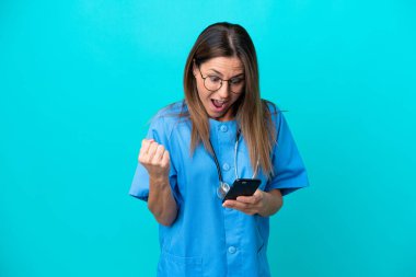 Mavi arka planda izole edilmiş orta yaşlı cerrah kadın şaşırdı ve bir mesaj gönderiyor.
