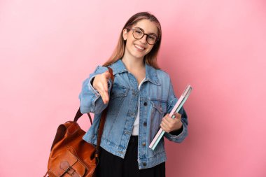 Pembe arka planda izole edilmiş beyaz bir kadın iyi bir anlaşma için el sıkışıyor.