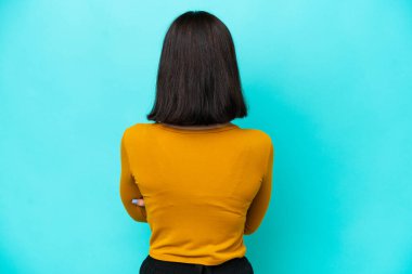 Genç beyaz kadın arka planda mavi arka planda izole edilmiş.