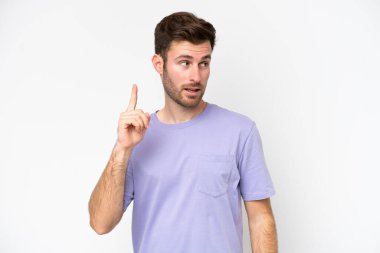 Beyaz arka planda izole edilmiş genç beyaz bir adam çözümü bulmak için parmağını kaldırıyor.