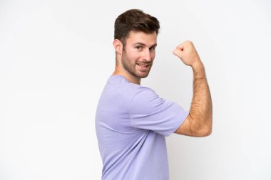 Beyaz arka planda izole genç beyaz adam güçlü jest yapıyor.
