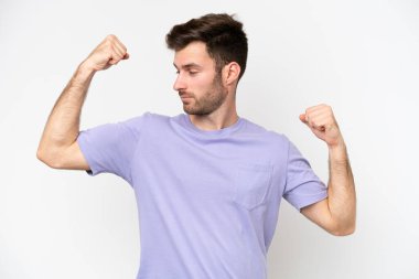 Beyaz arka planda izole genç beyaz adam güçlü jest yapıyor.