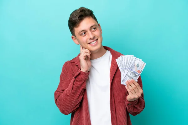 Junger Brasilianischer Mann Nimmt Viel Geld Isoliert Auf Blauem Hintergrund — Stockfoto