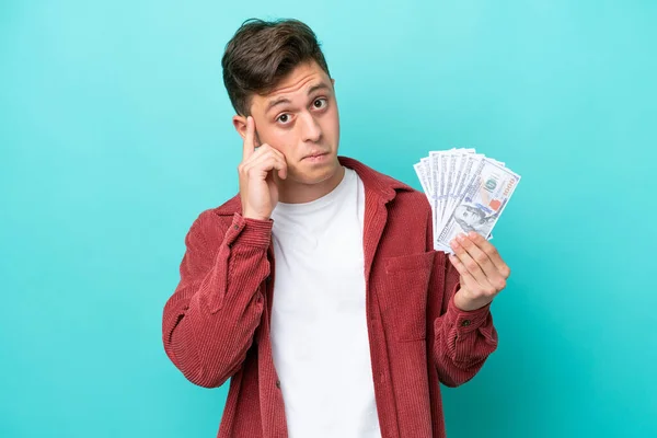 Young Brazilian Man Taking Lot Money Isolated Blue Background Thinking — стоковое фото