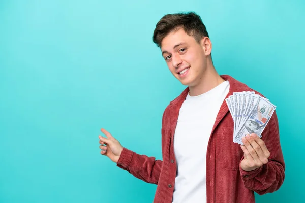 Young Brazilian Man Taking Lot Money Isolated Blue Background Pointing — Zdjęcie stockowe