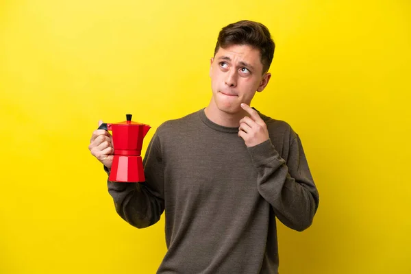 Young Brazilian Man Holding Coffee Pot Isolated Yellow Background Having — Fotografia de Stock
