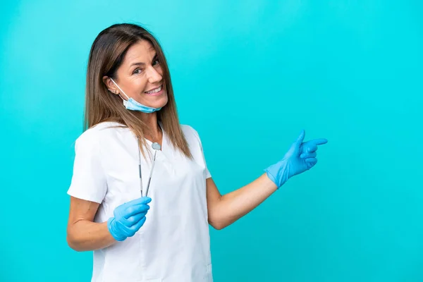 Lekarz Średnim Wieku Kobieta Odizolowana Niebieskim Tle Wskazując Palcem Bok — Zdjęcie stockowe