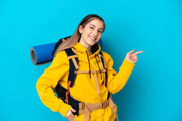 Young Mountaineer Woman Big Backpack Isolated Blue Background Pointing Finger —  Fotos de Stock