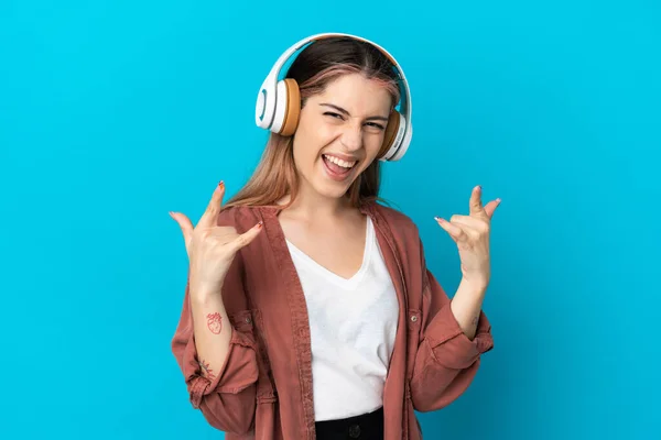Νεαρή Καυκάσια Γυναίκα Απομονωμένη Μπλε Φόντο Ακούγοντας Μουσική Κάνοντας Ροκ — Φωτογραφία Αρχείου