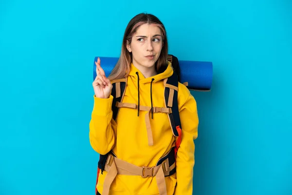 Young Mountaineer Woman Big Backpack Isolated Blue Background Fingers Crossing —  Fotos de Stock