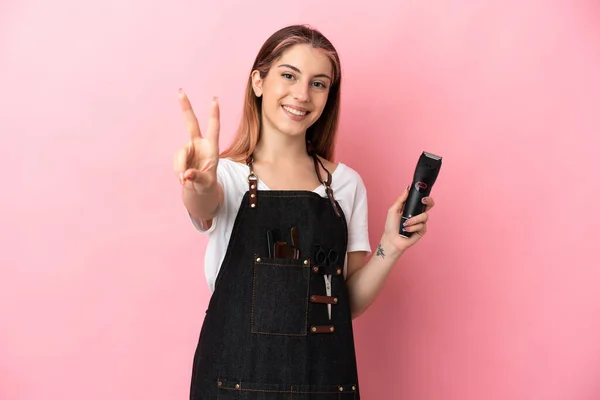 Giovane Parrucchiere Donna Isolata Sfondo Rosa Sorridente Mostrando Segno Vittoria — Foto Stock